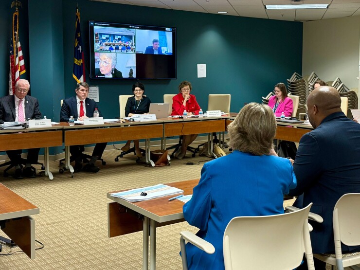 North Carolina Local Government Commission officials in background questioning Rocky Mount city officials in foreground